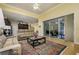 Open concept living area with a kitchen view, leather sofas, and a large area rug at 8444 Shenandoah Run, Wesley Chapel, FL 33544