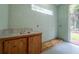 Convenient wet bar with a sink, wooden cabinets, and tile countertop at 8444 Shenandoah Run, Wesley Chapel, FL 33544