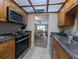 Galley kitchen with wood cabinets, stainless steel appliances, looking towards the living area at 8765 Bardmoor Blvd # 108, Seminole, FL 33777
