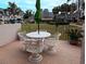 Cozy patio with a round table, four chairs, and garden views perfect for outdoor relaxation at 8765 Bardmoor Blvd # 108, Seminole, FL 33777
