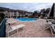 Community pool surrounded by lounge chairs on a brick-laid deck at 8765 Bardmoor Blvd # 108, Seminole, FL 33777
