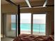 Bedroom with a four poster bed and sliding glass doors that open to a balcony with ocean views at 880 Mandalay Ave # C1103, Clearwater Beach, FL 33767