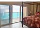 Bedroom with a four poster bed and sliding glass doors that open to a balcony with ocean views at 880 Mandalay Ave # C1103, Clearwater Beach, FL 33767