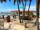 Grilling area with stainless steel grills with a lush tropical landscape, a pool and a beach in the background at 880 Mandalay Ave # C1103, Clearwater Beach, FL 33767