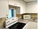 Bright kitchen equipped with white cabinetry, an electric range, and a microwave, ready for gourmet meals at 880 Mandalay Ave # C1103, Clearwater Beach, FL 33767