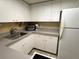 Bright, white kitchen with stainless steel sink and appliances, plus ample counter space at 880 Mandalay Ave # C1103, Clearwater Beach, FL 33767