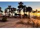 Outdoor patio featuring tables and chairs under umbrellas with palm trees at 880 Mandalay Ave # C1103, Clearwater Beach, FL 33767