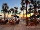 Outdoor dining area with palm trees and sunset views over the water at 880 Mandalay Ave # C1103, Clearwater Beach, FL 33767