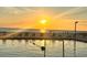 Stunning sunset view from the poolside with lounge chairs by the water at 880 Mandalay Ave # C1103, Clearwater Beach, FL 33767