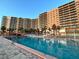 Large pool with a clear blue sky and a multi-story condominium complex with many balconies in the background at 880 Mandalay Ave # C1103, Clearwater Beach, FL 33767