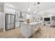 Modern kitchen with white cabinets, stainless steel appliances, large island with bar seating, and wood flooring at 9402 Woodbay Dr, Tampa, FL 33626