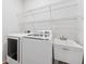 Clean laundry room with white appliances, wire shelving, and a utility sink for added convenience at 9402 Woodbay Dr, Tampa, FL 33626