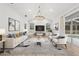 Well-lit living room with wood floors, large windows, modern lighting, and views of the outdoor pool area at 9402 Woodbay Dr, Tampa, FL 33626