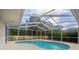 Views of the screened-in pool offering a private backyard oasis with lush greenery at 9402 Woodbay Dr, Tampa, FL 33626