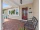 A covered front porch featuring neutral stucco exterior, brick pavers and decorative front door at 715 45Th Ne Ave, St Petersburg, FL 33703