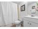 Bright bathroom featuring a white vanity, toilet and shower/tub combo with a stylish, decorative shower curtain at 10213 Westport Ct, Tampa, FL 33615
