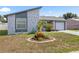 Charming home featuring a unique stone accent wall, well-maintained lawn, and lovely front garden at 10213 Westport Ct, Tampa, FL 33615