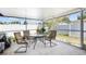 Enclosed patio area with glass-topped table and four chairs, perfect for enjoying the outdoors, shielded from bugs at 10213 Westport Ct, Tampa, FL 33615