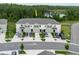Aerial view showcases townhomes with driveways, landscaping, and a serene lake in the background at 11054 Crescent Deer Dr, Land O Lakes, FL 34638