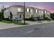Well-maintained townhomes with green lawns, driveways and neutral color schemes, captured at dusk at 11054 Crescent Deer Dr, Land O Lakes, FL 34638