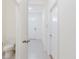 Bright hallway view with a white door, grey tile, and a glimpse of the front door at 11054 Crescent Deer Dr, Land O Lakes, FL 34638