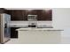 Close up on kitchen featuring stainless steel appliances, dark cabinets, and granite countertops at 11054 Crescent Deer Dr, Land O Lakes, FL 34638