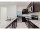 Modern kitchen with gray granite countertops, stainless steel appliances and dark cabinets at 11054 Crescent Deer Dr, Land O Lakes, FL 34638