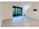 Open living space with sliding glass doors, stairs, and gray tile flooring at 11054 Crescent Deer Dr, Land O Lakes, FL 34638