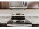 Close up of a stainless steel stove and granite countertops at 11054 Crescent Deer Dr, Land O Lakes, FL 34638