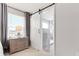 This primary bathroom boasts a sliding barn door, leading to a luxurious tiled shower at 11719 Tetrafin Dr, Riverview, FL 33579