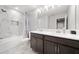 Bright bathroom features double vanity, modern fixtures, and a shower-tub combo with elegant tile surround at 11719 Tetrafin Dr, Riverview, FL 33579