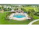 Aerial view of a community pool with a splashpad, lounge chairs, and beautiful landscaping at 11719 Tetrafin Dr, Riverview, FL 33579