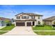 Two-story home featuring a manicured lawn, 2 car garage, and neutral paint at 11719 Tetrafin Dr, Riverview, FL 33579