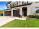 Well-manicured lawn and landscaping lead up to this two car garage and front door at 11719 Tetrafin Dr, Riverview, FL 33579