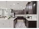 Stylish kitchen featuring stainless steel appliances, marble countertops, and dark wood cabinets at 11719 Tetrafin Dr, Riverview, FL 33579