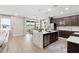 Modern kitchen featuring a large marble island, stainless steel appliances, and dark wood cabinets at 11719 Tetrafin Dr, Riverview, FL 33579