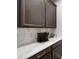 Wet bar area features dark cabinets, marble backsplash, and countertops plus a coffee maker at 11719 Tetrafin Dr, Riverview, FL 33579