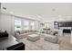 Open-concept living room with large sectional sofa and view of modern kitchen at 11719 Tetrafin Dr, Riverview, FL 33579