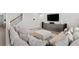 Open-concept living room features a large comfortable couch and modern entertainment center at 11719 Tetrafin Dr, Riverview, FL 33579