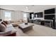 Spacious living room with large sectional sofa, wooden coffee table, and entertainment center with multiple screens at 11719 Tetrafin Dr, Riverview, FL 33579