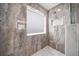 Step into luxury with this tiled shower, complete with a niche, rainfall showerhead, and marble accents at 11719 Tetrafin Dr, Riverview, FL 33579