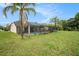 The backyard offers a screened-in pool, spa, and expansive green space at 12214 Buckingham Way, Spring Hill, FL 34609