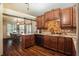 Modern kitchen featuring wood cabinetry, granite countertops, stone backsplash, and adjacent dining area at 12214 Buckingham Way, Spring Hill, FL 34609