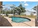 Backyard with screened-in pool area, brick patio and a spacious lawn at 12436 Oak St, San Antonio, FL 33576