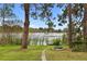 Beautiful backyard with lush greenery, a stone path, a lake view and a fire pit at 12529 Mondragon Dr, Tampa, FL 33625
