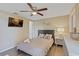 Comfortable bedroom featuring a cozy queen bed, a wall-mounted TV, and ample natural light at 12529 Mondragon Dr, Tampa, FL 33625