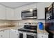 Modern kitchen with stainless steel appliances, granite countertops, and ample cabinet space at 12529 Mondragon Dr, Tampa, FL 33625