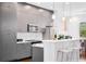 Modern kitchen with gray cabinets, stainless steel appliances, pendant lighting, and breakfast bar seating at 1330 W Gray St # 2, Tampa, FL 33606
