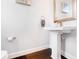 Elegant powder room features a pedestal sink, dark wood floors, and modern fixtures for a sophisticated touch at 1330 W Gray St # 2, Tampa, FL 33606