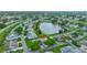 Aerial view showcasing a well-planned residential community with a lake, manicured lawns, and mature trees at 1417 Langley Dr, Sun City Center, FL 33573